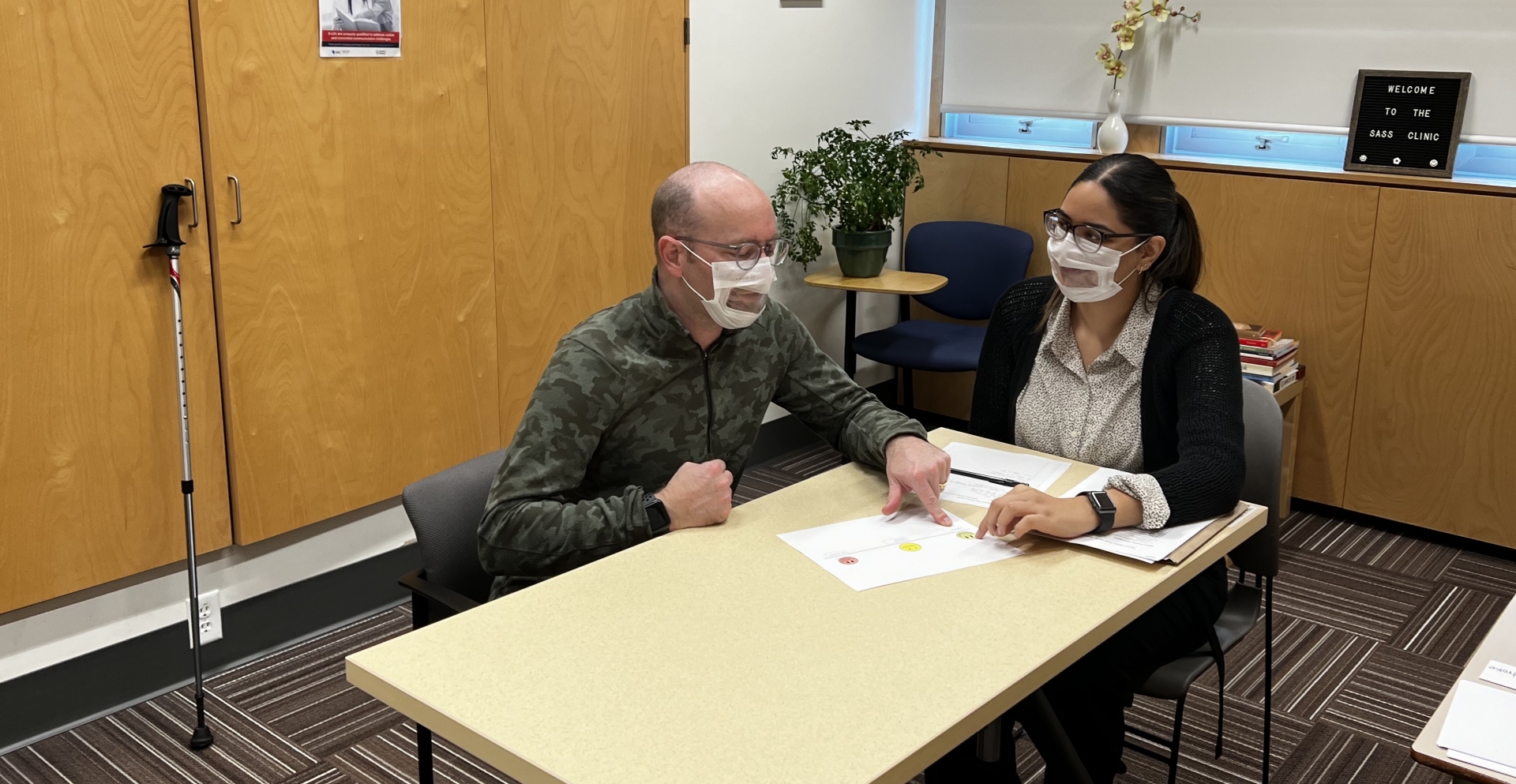 Speech Language Pathologist Student working with a client, both sitting at a table.