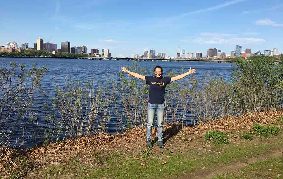 A photo of Paris standing in front of Boston harbour with her arms spread