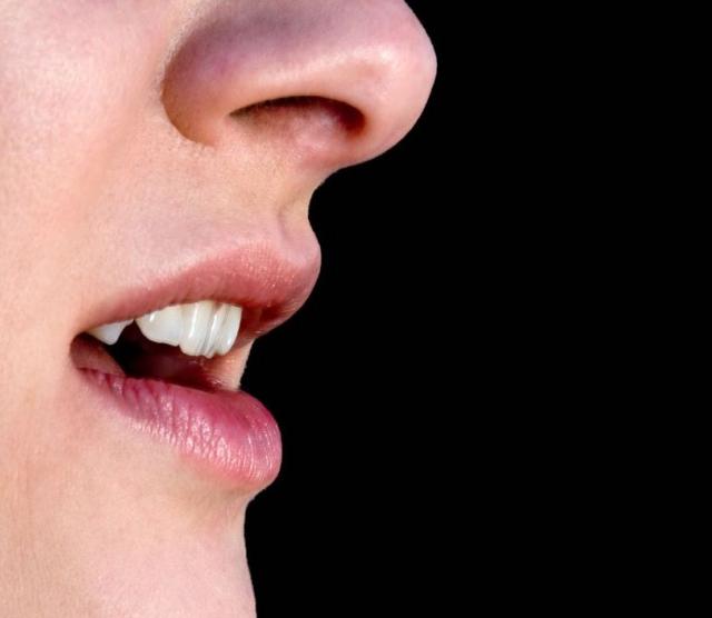 Image of a person's face, showing the nose to chin area. The person's mouth is open.