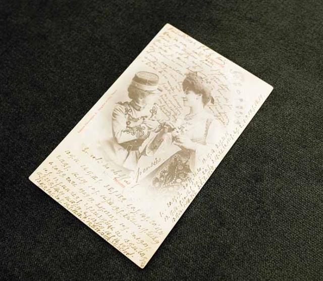 A picture of a postcard from 1902 France, containing a secret love message written in code between two women. This postcard is part of the A Queer Century exhibition on display at UBC until August 30 2019.