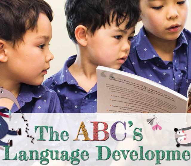 Three children in blue shirts reading a book