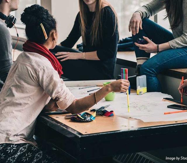 A group of people seated around a table talking