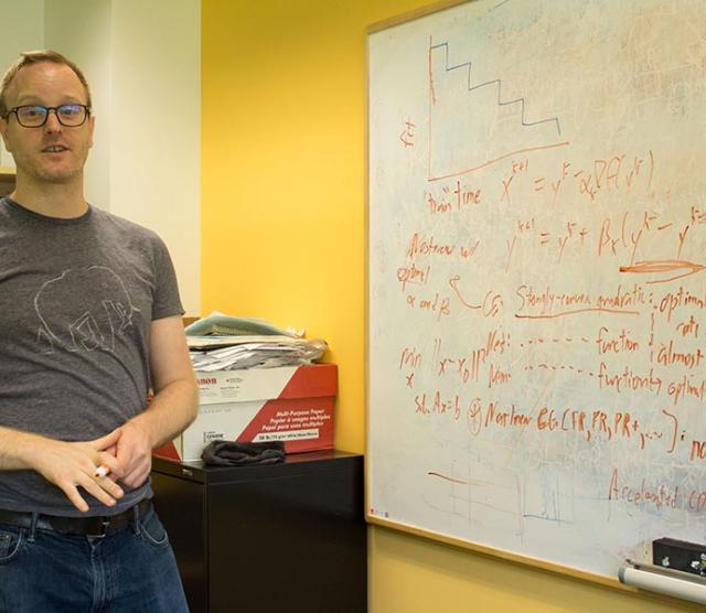 Mark Schmidt is pictured demonstrating some of the principles behind machine learning on a whiteboard.