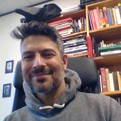 A headshot of Jason Lieblang sitting in front of a bookcase