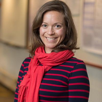 A headshot of Molly Babel standing outside and wearing a red scarf