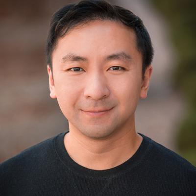 A headshot of Raymond Pai wearing a black t-shirt