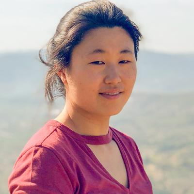 A headshot of Sheri Choi standing outside