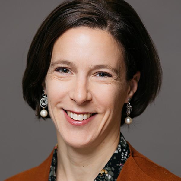 A headshot of Dr. Hinnell against a grey background