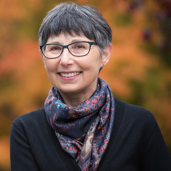 A headshot of Janet Werker standing outside and wearing a scarf