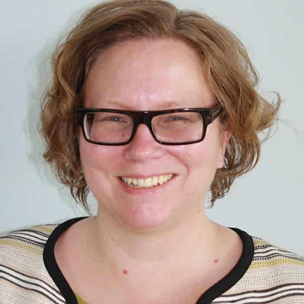 A headshot of Lynne Williams standing in front of a white background